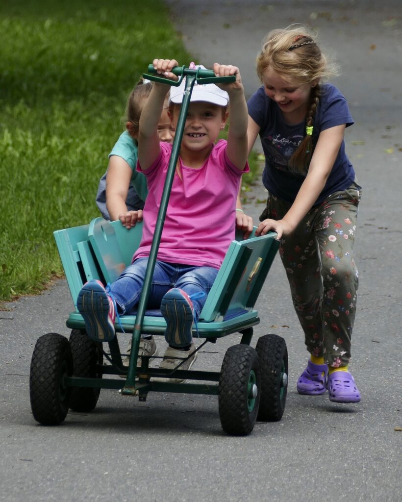 tres niñas jugando con un carrito divertidas
